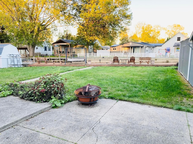 view of yard featuring a patio, a shed, and a fire pit