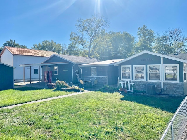 view of front of house with cooling unit, a front yard, and a patio area