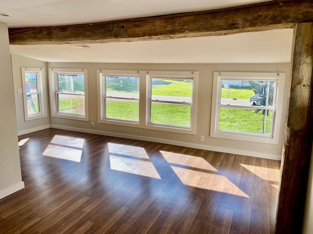 spare room with dark hardwood / wood-style floors and beam ceiling