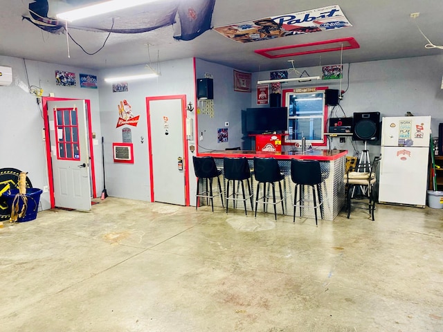 garage featuring white fridge and an AC wall unit