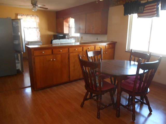 kitchen featuring stainless steel fridge, ceiling fan, and light hardwood / wood-style flooring