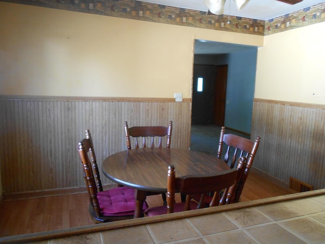 dining space with ceiling fan and hardwood / wood-style flooring