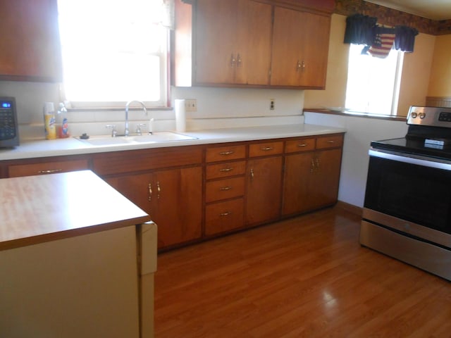 kitchen with light hardwood / wood-style floors, sink, and stainless steel range