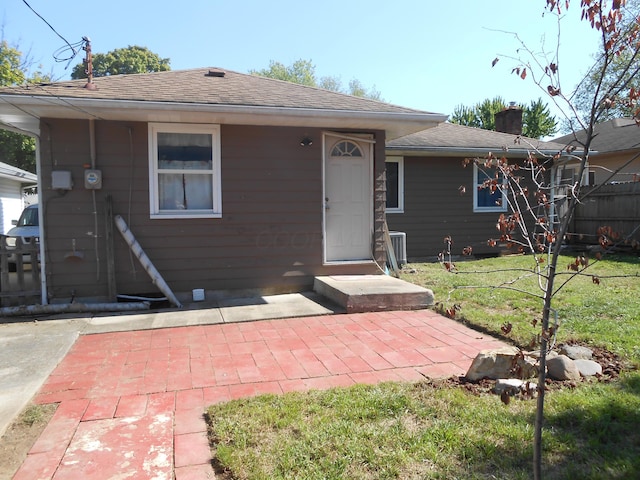 view of front of property with central air condition unit, a patio area, and a front lawn