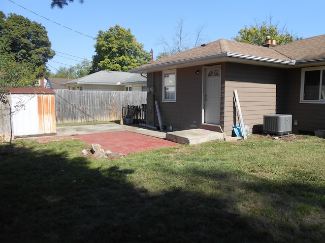 rear view of house with a patio, central AC unit, and a lawn