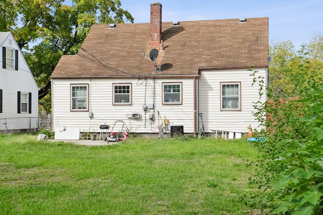 rear view of property featuring a lawn