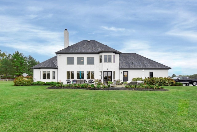 rear view of house featuring outdoor lounge area and a yard