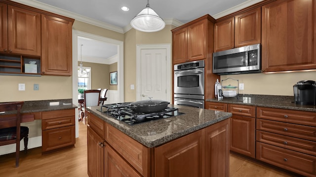 kitchen with appliances with stainless steel finishes, crown molding, decorative light fixtures, a center island, and light hardwood / wood-style floors