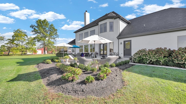 back of property with outdoor lounge area, a patio area, and a lawn