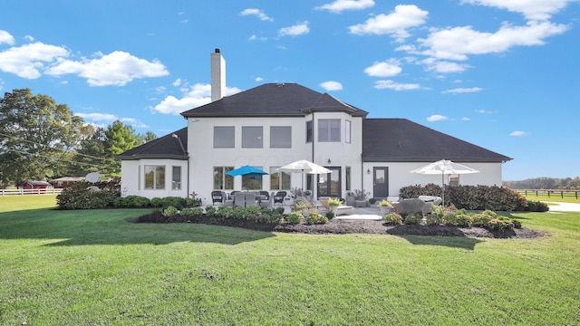 back of property featuring a lawn, an outdoor hangout area, and a patio