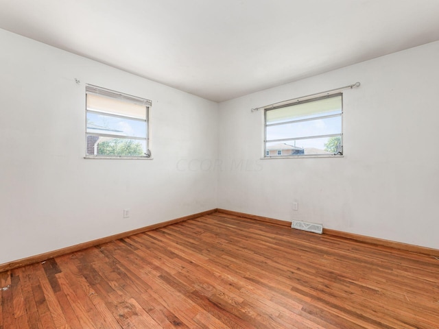 unfurnished room featuring hardwood / wood-style floors and a healthy amount of sunlight