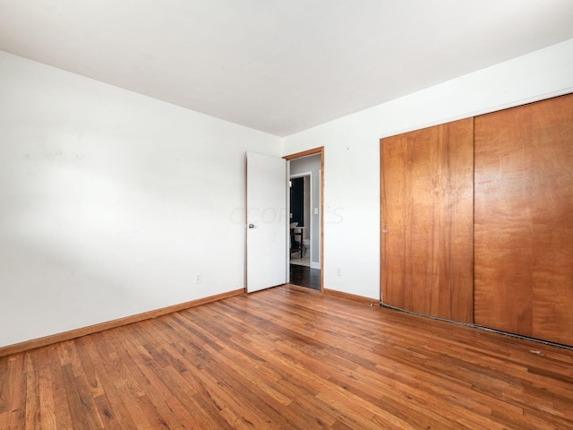 unfurnished bedroom featuring hardwood / wood-style floors and a closet