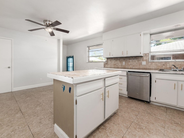 kitchen featuring stainless steel dishwasher, a kitchen island, white cabinetry, and sink