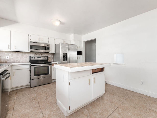 kitchen with decorative backsplash, appliances with stainless steel finishes, a center island, and white cabinetry