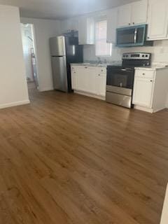 kitchen with white cabinetry, stainless steel appliances, and dark wood-type flooring