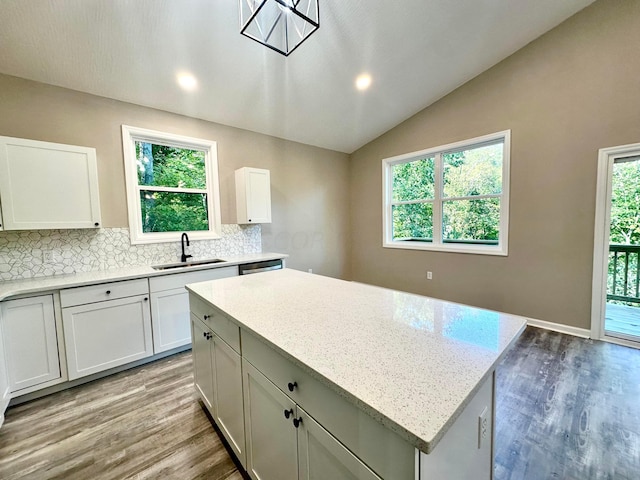 kitchen featuring white cabinets, a wealth of natural light, lofted ceiling, and sink