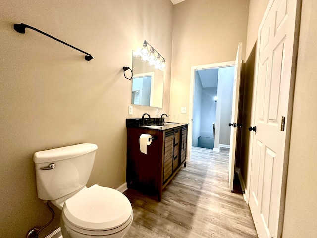 bathroom featuring wood-type flooring, vanity, and toilet