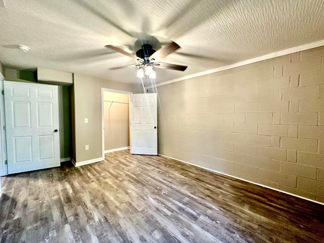 unfurnished bedroom featuring wood-type flooring, a textured ceiling, ceiling fan, and crown molding