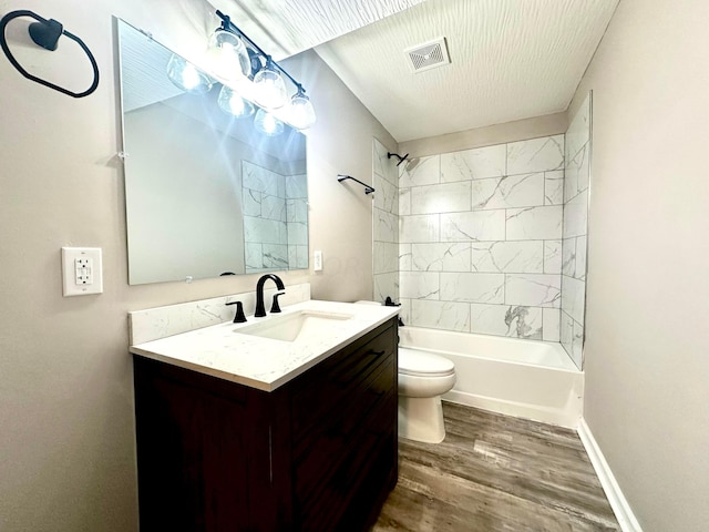 full bathroom with vanity, hardwood / wood-style flooring, toilet, and tiled shower / bath