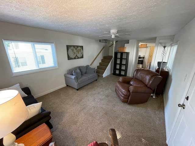 carpeted living room featuring ceiling fan and a textured ceiling