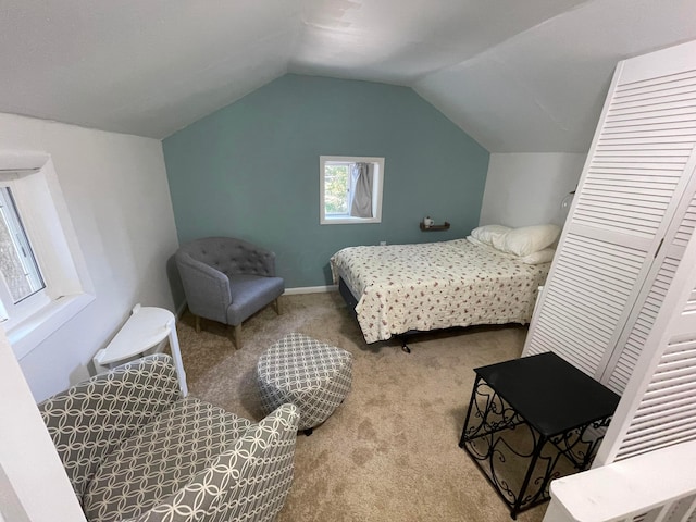 carpeted bedroom with vaulted ceiling and a closet