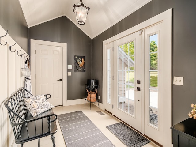 entryway with light tile patterned floors and vaulted ceiling