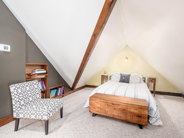 bedroom with vaulted ceiling with beams and carpet