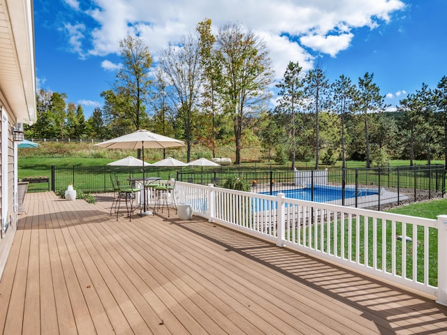 wooden terrace featuring a fenced in pool and a lawn