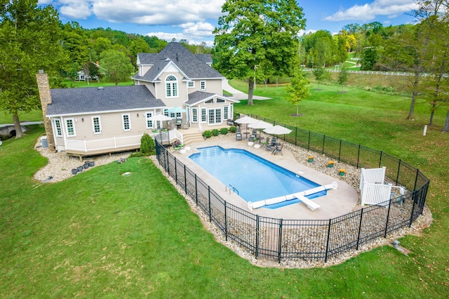 view of pool with a diving board, a yard, and a patio