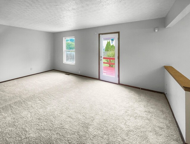 carpeted spare room with a textured ceiling