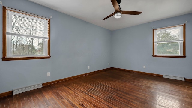 empty room with a baseboard heating unit, dark hardwood / wood-style floors, and ceiling fan