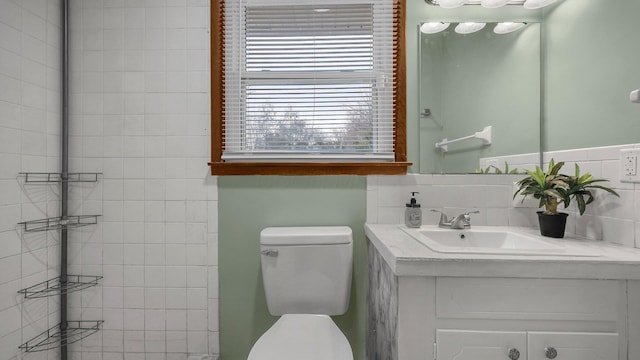 bathroom featuring vanity, toilet, and decorative backsplash