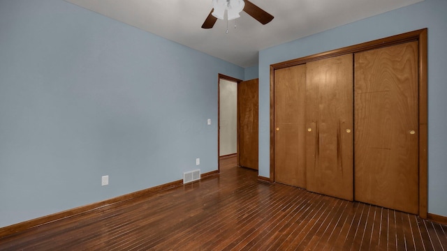 unfurnished bedroom featuring dark wood-type flooring, ceiling fan, and a closet