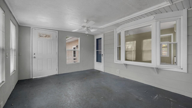 unfurnished sunroom featuring ceiling fan