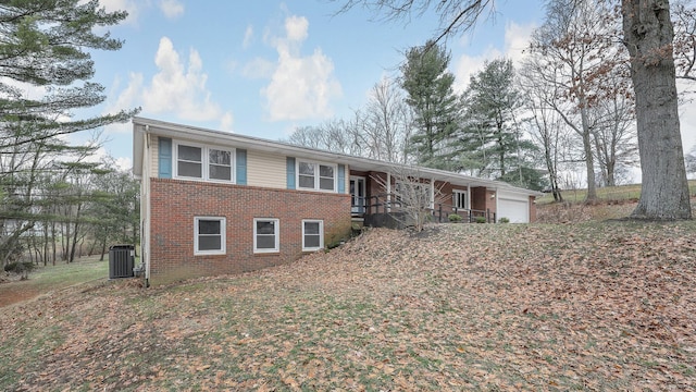 view of front of property featuring a garage and cooling unit