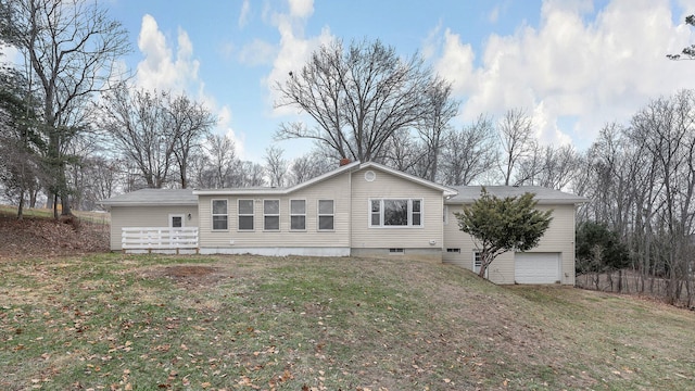 rear view of property featuring a yard and a garage