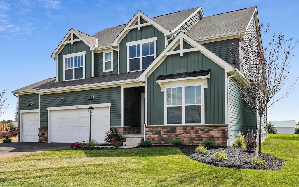 craftsman-style house featuring a front yard and a garage