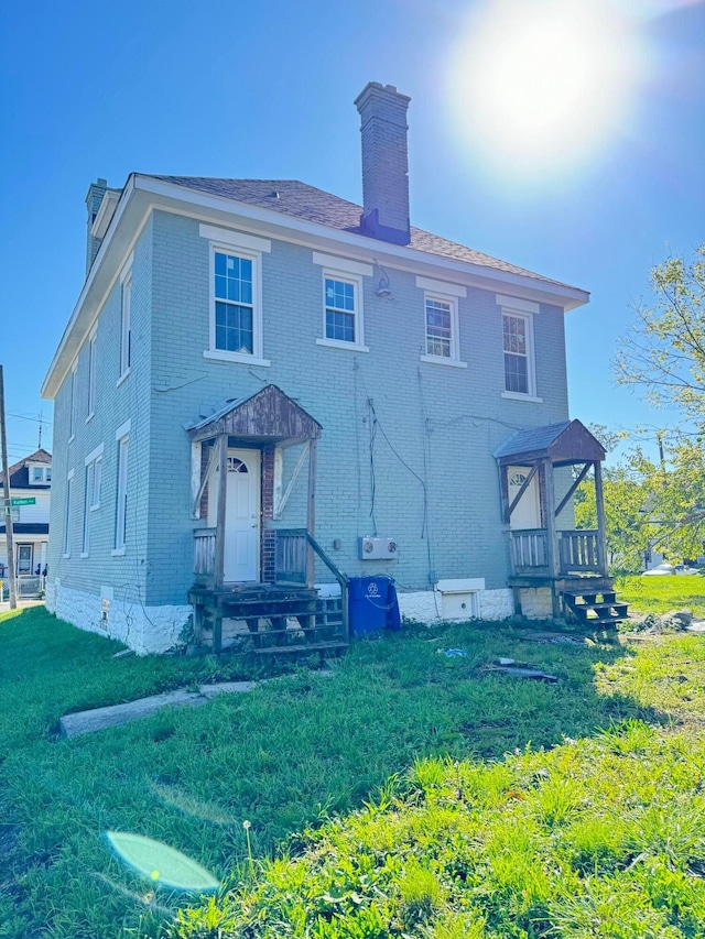 back of property featuring a lawn