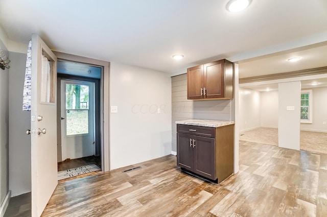 kitchen with light hardwood / wood-style flooring and dark brown cabinetry