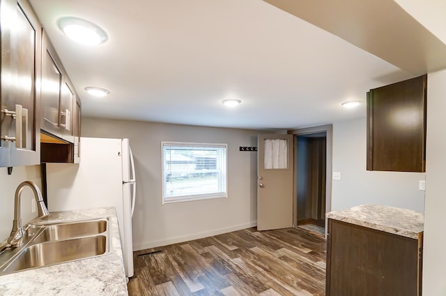 kitchen with sink, dark brown cabinets, and dark wood-type flooring