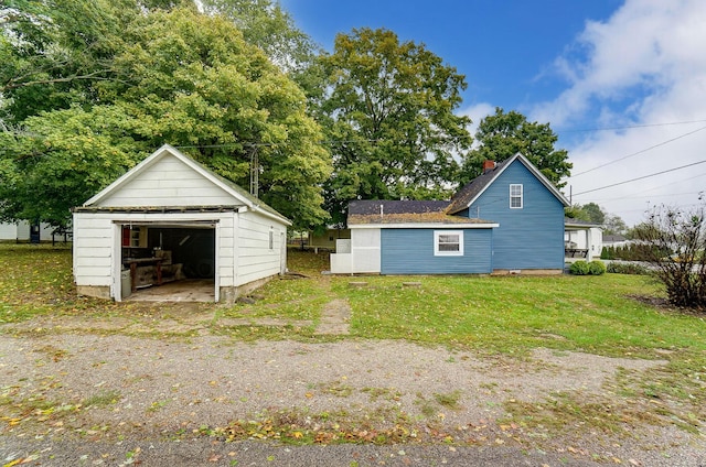 exterior space featuring a garage, an outdoor structure, and a lawn