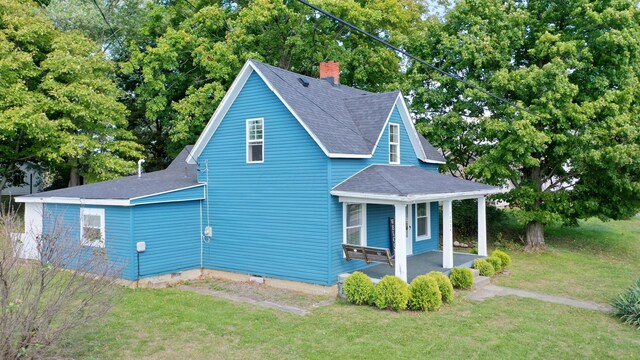 view of property exterior featuring a yard and covered porch