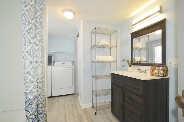 bathroom featuring a shower with curtain, hardwood / wood-style flooring, washing machine and dryer, and vanity