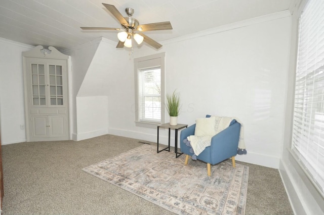 sitting room with carpet flooring, ornamental molding, and ceiling fan