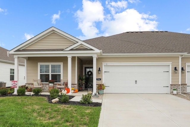 view of front of property with cooling unit, covered porch, a front yard, and a garage