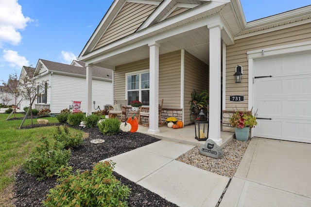 entrance to property with covered porch and a garage