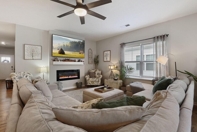 living room with hardwood / wood-style flooring, a wealth of natural light, and ceiling fan