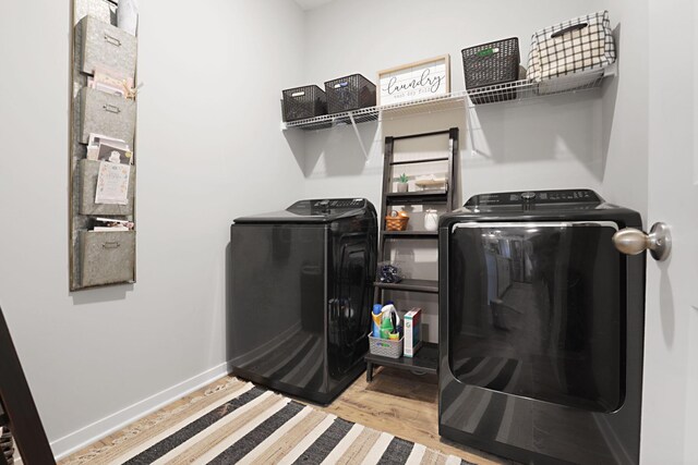 laundry room with light hardwood / wood-style floors and separate washer and dryer