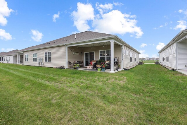 back of property featuring a lawn and a patio area