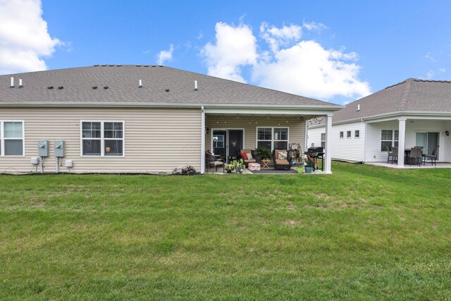 rear view of property featuring a lawn and a patio area